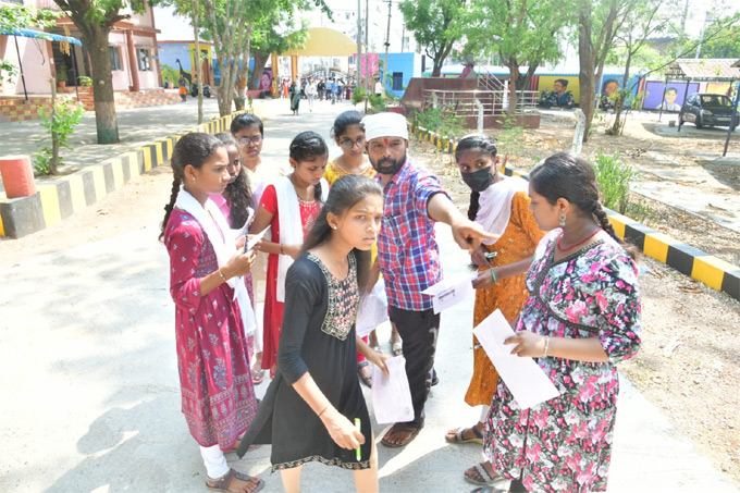పరీక్షకేంద్రం వద్ద విద్యార్థులకు సూచనలు ఇస్తున్న సిబ్బంది
