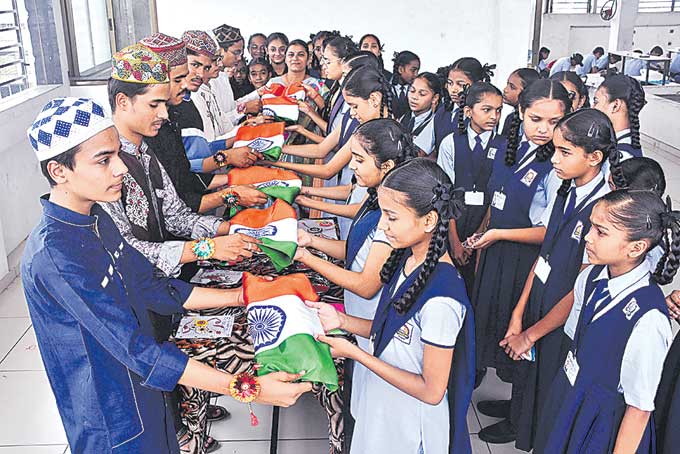 రక్షాబంధన్ను పురస్కరించుకుని గుజరాత్లోని సూరత్లో రాఖీ కట్టిన విద్యార్థినులకు జాతీయ జెండాను బహుకరిస్తున్న ముస్లిం విద్యార్థులు.