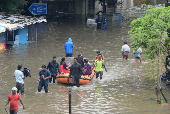 వరద నీటిలో నుంచి వెళ్తున్న ప్రజలు
